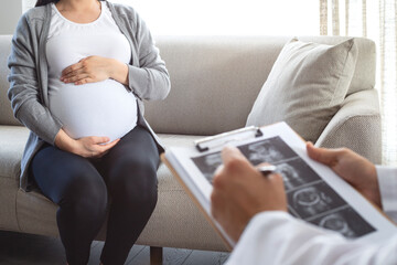 Gynecologist looks at an ultrasound of a pregnant woman. Prenatal health care. 