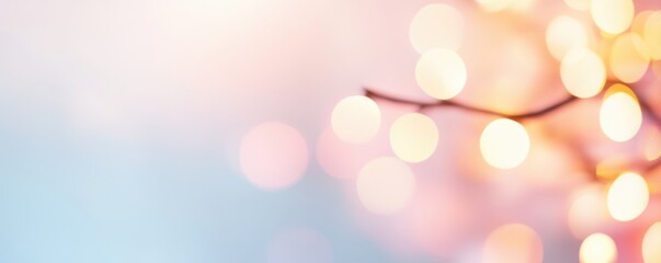 Obraz premium Bokeh light circles in yellow and pink on a gradient blue and pink background with a blurred branch