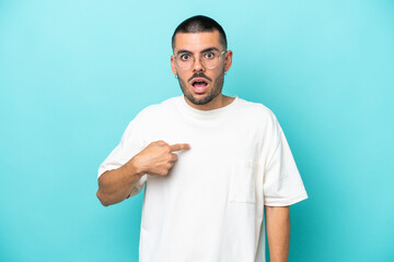 Young caucasian man isolated on blue background pointing to oneself