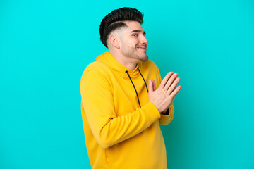 Young caucasian man isolated on blue background scheming something