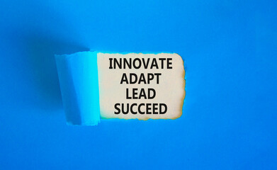Innovate adapt lead succeed symbol. Concept words Innovate Adapt Lead Succeed on beautiful white paper. Beautiful blue table blue background. Business innovate adapt lead succeed concept. Copy space.