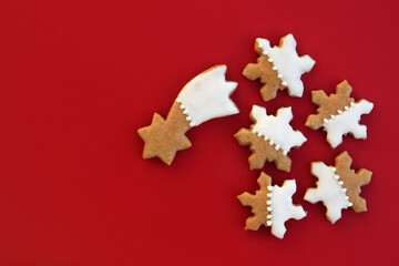 Gingerbread comet and snowflakes on a red background, copy space for text
