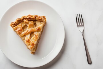 Freshly baked apple pie slice served on a white plate with a fork beside it