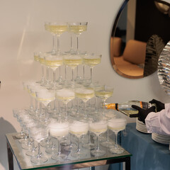 Towering pyramid of champagne glasses filled with bubbly
