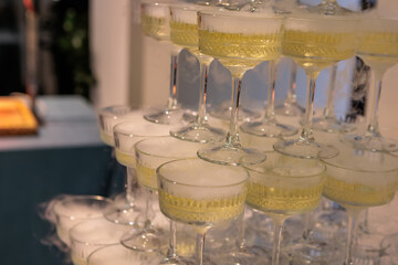 Towering pyramid of champagne glasses filled with bubbly