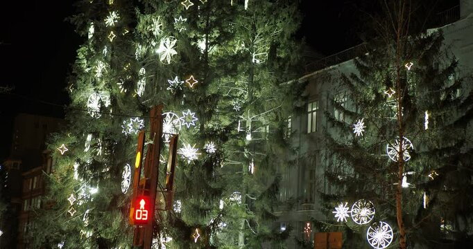 The traffic light counts down the seconds before switching from red to green against the background of Christmas trees decorated with toys and burning garlands . Camera rotation. Hand held. Siberia.