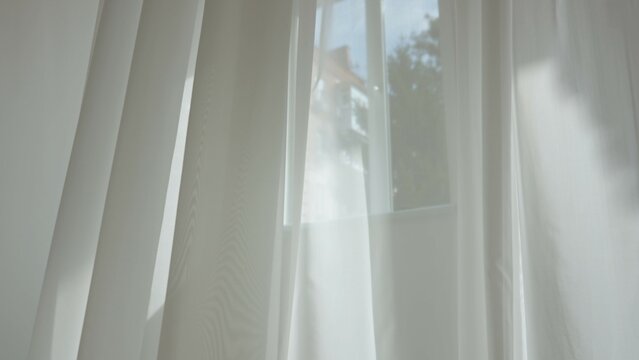 Transparent blurred white silk soft fabrics floating with sunlight from open window shining through, shadows reflected on the textile surface. - Powered by Adobe