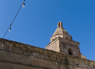 minimalist view of stone bell tower against blue sky