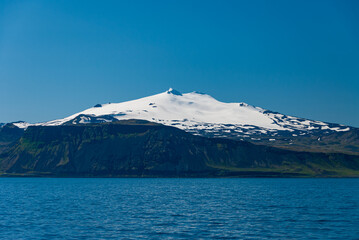 Snaefellsjökull is a 700,000 year old volcano covered by a glacier from the last ice age. It is...