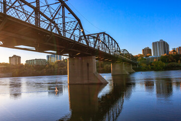 Naklejka premium A bridge spans a river with a city in the background