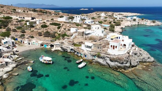 Aerial drone video of picturesque seaside area and bay of Goupa - Karra with colourful boat houses and elephant rock a perfect place to swim, Kimolos island, Cyclades, Greece