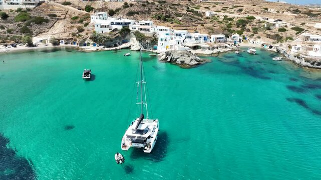 Aerial drone video of picturesque seaside area and bay of Goupa - Karra with colourful boat houses and elephant rock a perfect place to swim, Kimolos island, Cyclades, Greece