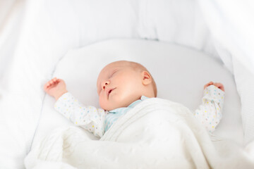 Cute newborn baby in white bed