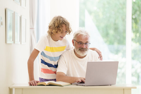 Senior man working on computer with grandchild