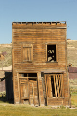 A dilapidated old building with a crooked roof and broken windows