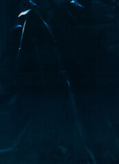 Old film overlay. Creased foil texture. Blue white color light flare dust scratch particles defect weathered crumpled effect worn filter teal dark illustration art abstract background.
