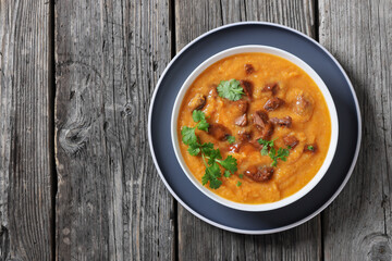 creamy carrot beef soup in a white bowl