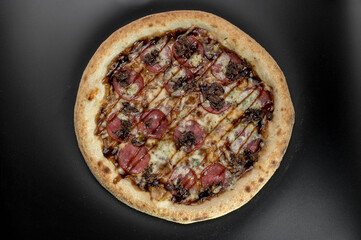 details of the pizza application; juicy pizza from the oven with mushrooms, tomatoes and bacon and sprinkled with parmesan cheese