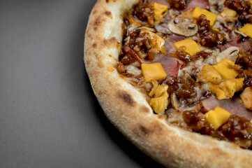 details of the pizza application; juicy pizza from the oven with mushrooms, tomatoes and bacon and sprinkled with parmesan cheese