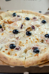 details of the pizza application; juicy pizza from the oven with mushrooms, tomatoes and bacon and sprinkled with parmesan cheese