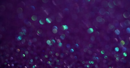 Bokeh shimmering. Dark violet. Small light flare spots of shining dust on lilac background. Blurred...