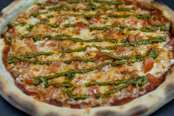 details of the pizza application; juicy pizza from the oven with mushrooms, tomatoes and bacon and sprinkled with parmesan cheese