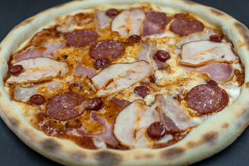 details of the pizza application; juicy pizza from the oven with mushrooms, tomatoes and bacon and sprinkled with parmesan cheese