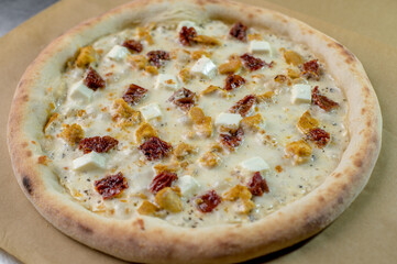 details of the pizza application; juicy pizza from the oven with mushrooms, tomatoes and bacon and sprinkled with parmesan cheese