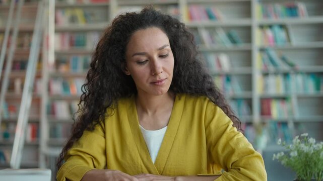 Latino Hispanic Arabian woman female student learner high school university learning studying college library reading book novel reader thinking contemplation bookstore happy girl bookworm imagination