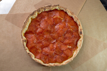 details of the pizza application; juicy pizza from the oven with mushrooms, tomatoes and bacon and sprinkled with parmesan cheese