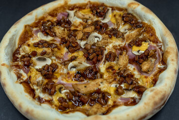 details of the pizza application; juicy pizza from the oven with mushrooms, tomatoes and bacon and sprinkled with parmesan cheese