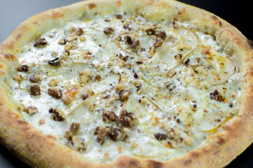 details of the pizza application; juicy pizza from the oven with mushrooms, tomatoes and bacon and sprinkled with parmesan cheese