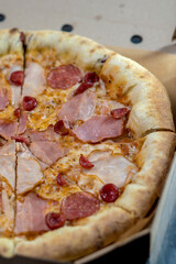 details of the pizza application; juicy pizza from the oven with mushrooms, tomatoes and bacon and sprinkled with parmesan cheese