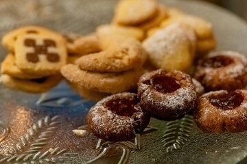 Homemade cookies and pastries arranged on a decorative plate during a cozy gathering in the evening