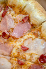 details of the pizza application; juicy pizza from the oven with mushrooms, tomatoes and bacon and sprinkled with parmesan cheese