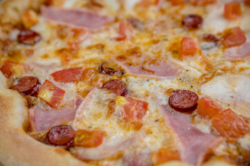 details of the pizza application; juicy pizza from the oven with mushrooms, tomatoes and bacon and sprinkled with parmesan cheese
