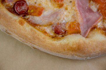 details of the pizza application; juicy pizza from the oven with mushrooms, tomatoes and bacon and sprinkled with parmesan cheese