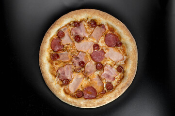 details of the pizza application; juicy pizza from the oven with mushrooms, tomatoes and bacon and sprinkled with parmesan cheese