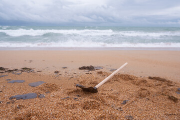 The volunteer's shovel is covered in fuel oil after the elimination of the terrible environmental disaster, the oil spill in the Black Sea