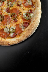 details of the pizza application; juicy pizza from the oven with mushrooms, tomatoes and bacon and sprinkled with parmesan cheese