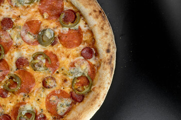details of the pizza application; juicy pizza from the oven with mushrooms, tomatoes and bacon and sprinkled with parmesan cheese