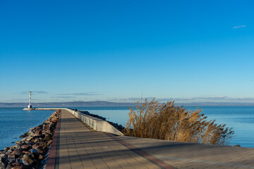 Spazierweg am Balaton mit Blick auf den Leuchtturm und Schilf in Si&oacute;fok, Ungarn