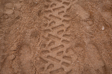A footprint in the sand from a truck wheel. The Black Sea coast. Elimination of a terrible environmental disaster, fuel oil spill in the sea