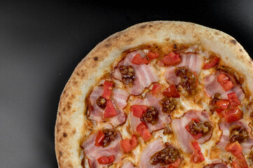 details of the pizza application; juicy pizza from the oven with mushrooms, tomatoes and bacon and sprinkled with parmesan cheese