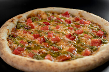 details of the pizza application; juicy pizza from the oven with mushrooms, tomatoes and bacon and sprinkled with parmesan cheese