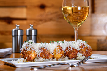 Parmesan Beignets drizzled with honey and diced pears and topped with fresh parmesan