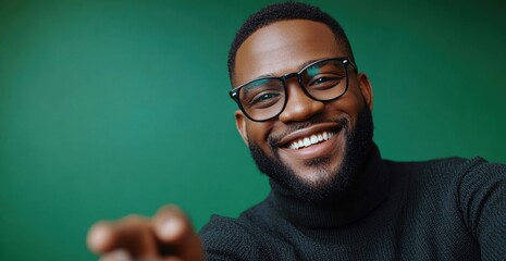 Obraz premium Smiling man wearing glasses and sweater, green background
