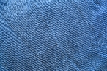 Blue wrinkled denim jeans fabric pattern texture background for fashion and design concepts