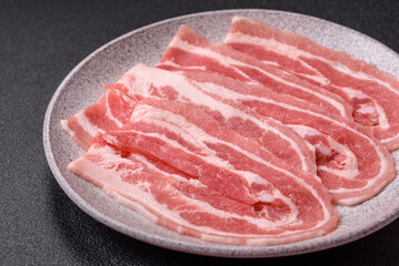 Fresh raw bacon sliced with spices and herbs