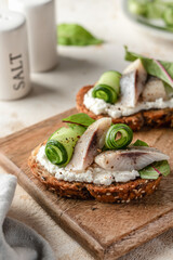 Little sandwiches bruschettas with pieces of salted herring cream cheese and cucumber. Appetizer, antipasti